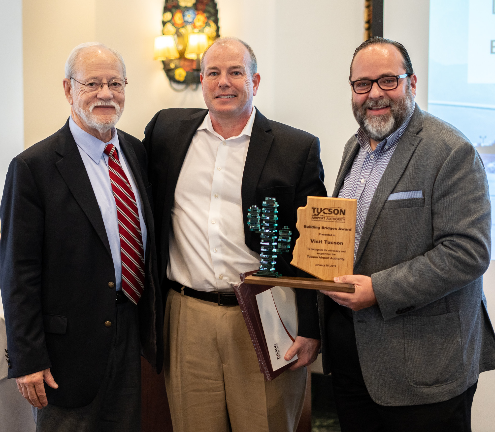 TAA Board Secretary Bruce Dusenberry, left, with Visit Tucson President and CEO Brent DeRaad and Executive Vice President Felipe Garcia receiving the Building Bridges Award.